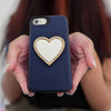 Wireless City heart shaped stick on mirror with rhinestone border on a navy phone case. Rose gold finish.