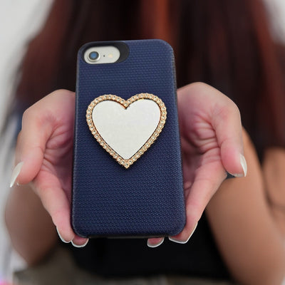 Wireless City heart shaped stick on mirror with rhinestone border on a navy phone case. Rose gold finish.